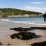 Une belle plage de sable se niche au fond d'une crique sur une côte principalement rocheuse